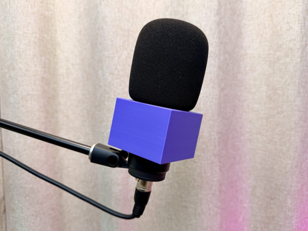 3D-printed custom mic flag with raised logo on a podcast microphone, made in Burbank